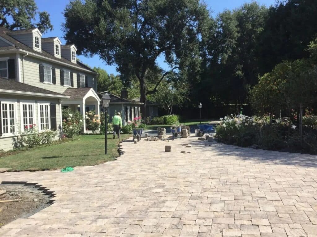 Custom interlocking paver driveway under construction in Woodside, CA, featuring elegant design elements and expert hardscape installation, enhancing the home's curb appeal.