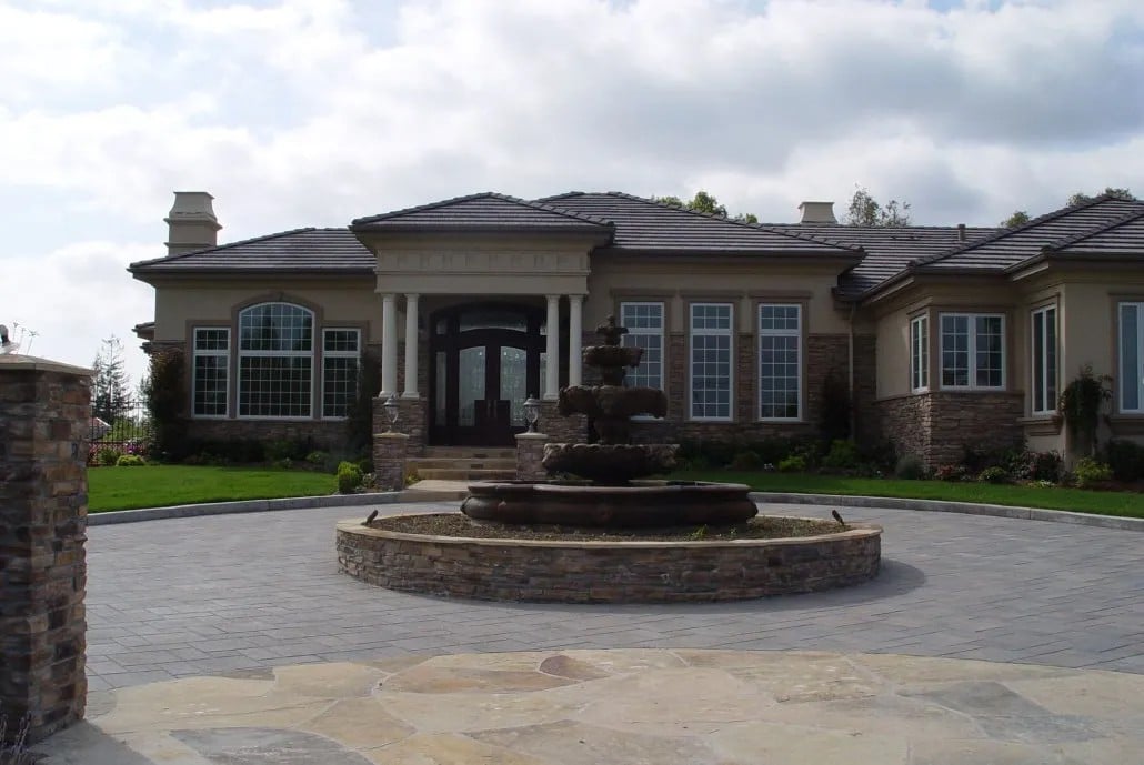 Elegant circular driveway design with a central stone fountain in Los Gatos, CA, highlighting expert hardscaping and luxury curb appeal enhancements.